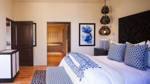 A bedroom with a large bed, a wooden door, a bathroom with a shower, and a ceiling fan. - Cabo Dream Stay-4BR Oceanview at Hacienda Beach Club can be rented as 2-3 bedrm (Cabo San Lucas)