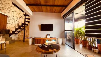 Loft de diseñador | Área de sala de estar | Smart TV de 32 pulgadas con canales por cable, televisión y Netflix