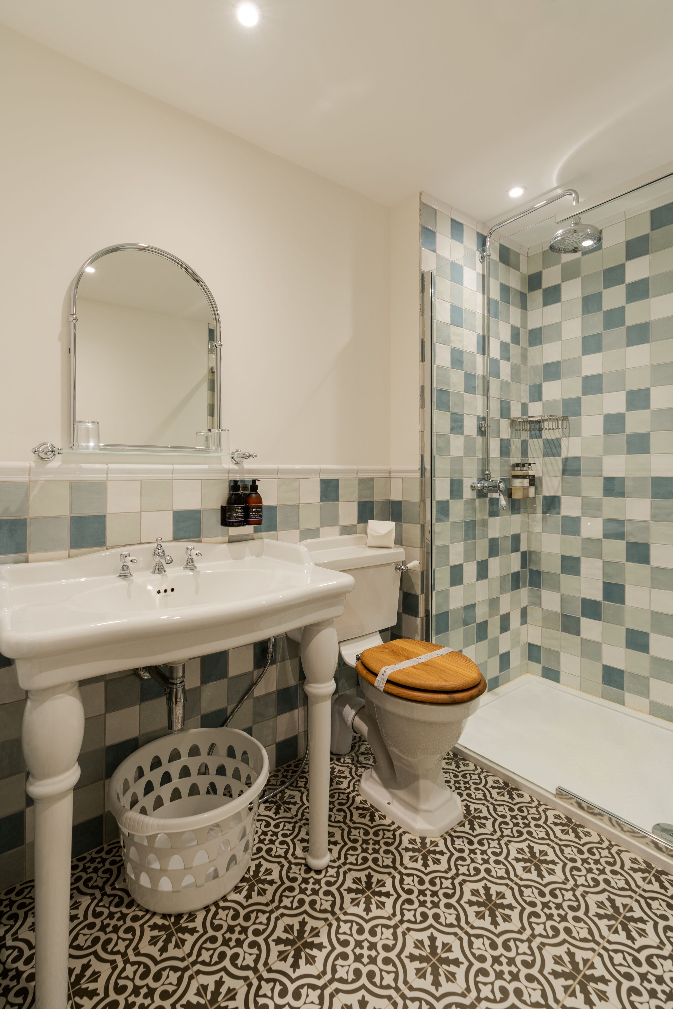 A bathroom with a sink, mirror, toilet, and shower.