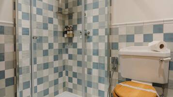 Een badkamer met een vloer van zwart-wit betegelde tegels, een douchecabine van glas en een toilet met houten zitting.