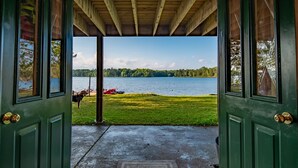 A view through a green door to a grassy area with a lake and trees in the background. - Fall Colors, ATV Trails & Lake Fishing Retreat (Crystal Falls)