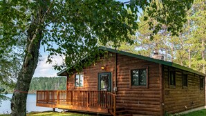 A wooden cabin with a deck, situated by a lake. - Fall Colors, ATV Trails & Lake Fishing Retreat (Crystal Falls)