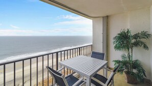 A balcony with a view of the ocean, a table, chairs, and a potted plant. - DAILY ACTIVITIES & LINENS INCLUDED*!! Direct Oceanfront  2  bedroom, 2 bath with an open den (set up as dining room). (Ocean City)