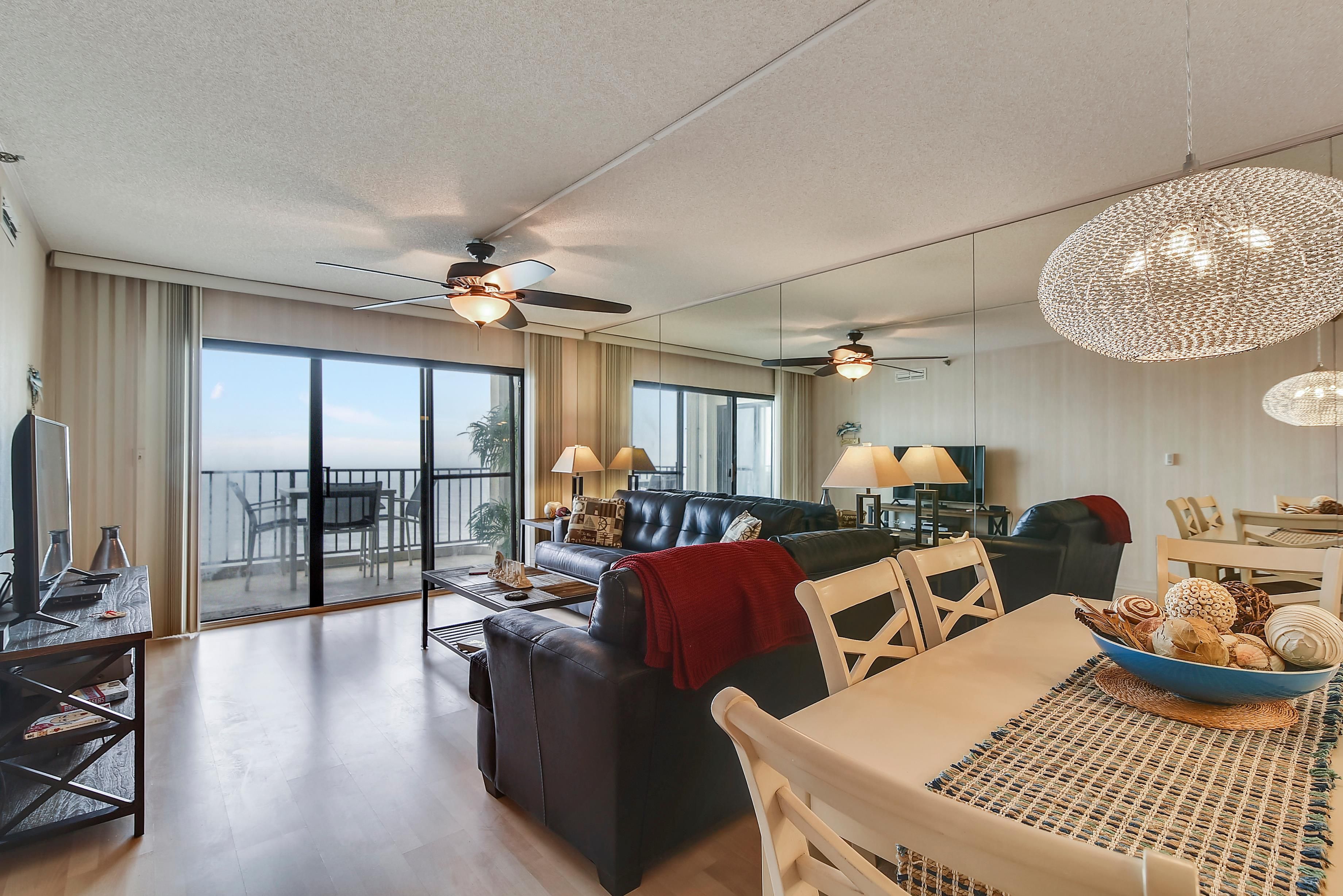 A spacious living area with a balcony, a dining table, and a sofa.