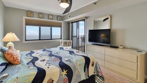 A bedroom with a bed, a ceiling fan, a TV, a dresser, and a window. - DAILY ACTIVITIES & LINENS INCLUDED*!! Direct Oceanfront  2  bedroom, 2 bath with an open den (set up as dining room). (Ocean City)