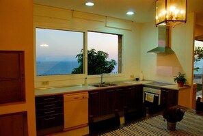 Enjoy ocean views from the kitchen window, featuring a dishwasher, stainless steel sink, and gas stove.
