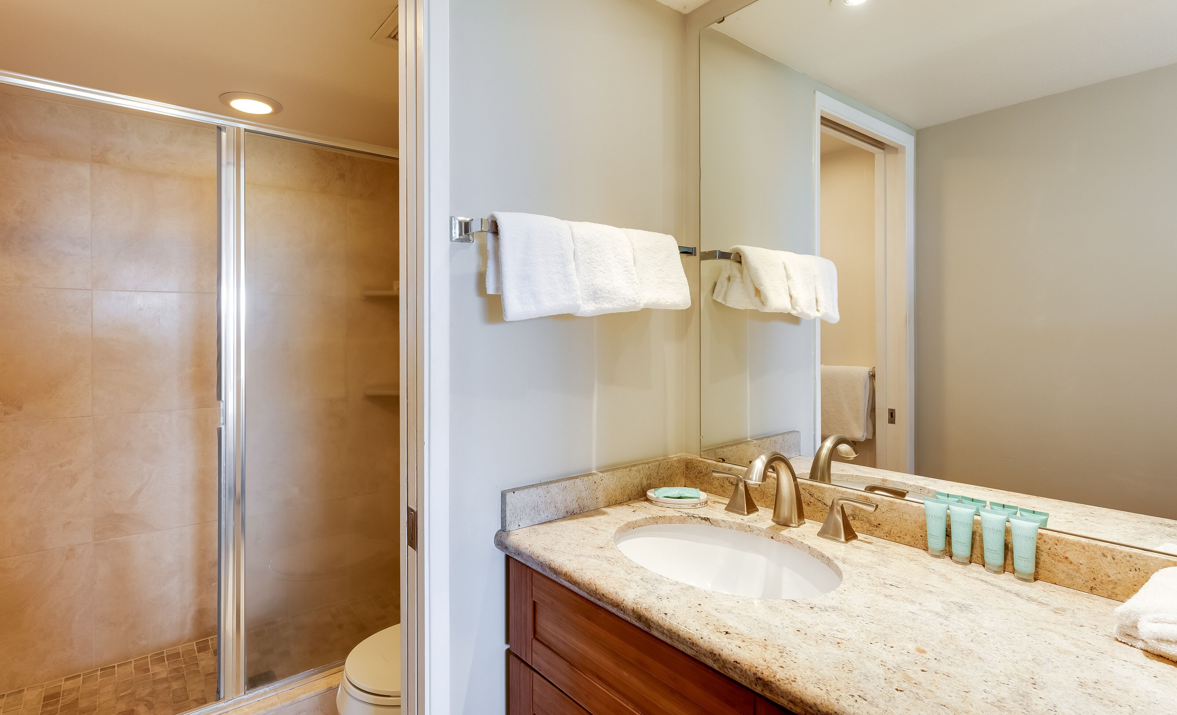 Ein Badezimmer mit Dusche, Waschbecken und Spiegel.