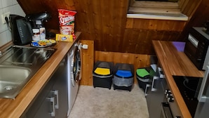 A compact kitchen with wooden walls, a sink, a coffee maker, and a microwave. - W4, apartment with air conditioning, 2 bedrooms with 4 single beds. (Hüllhorst)