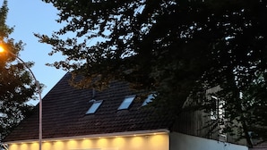 A building with a sloped roof, a single entrance with a door, and a small window on the side. - W4, apartment with air conditioning, 2 bedrooms with 4 single beds. (Hüllhorst)