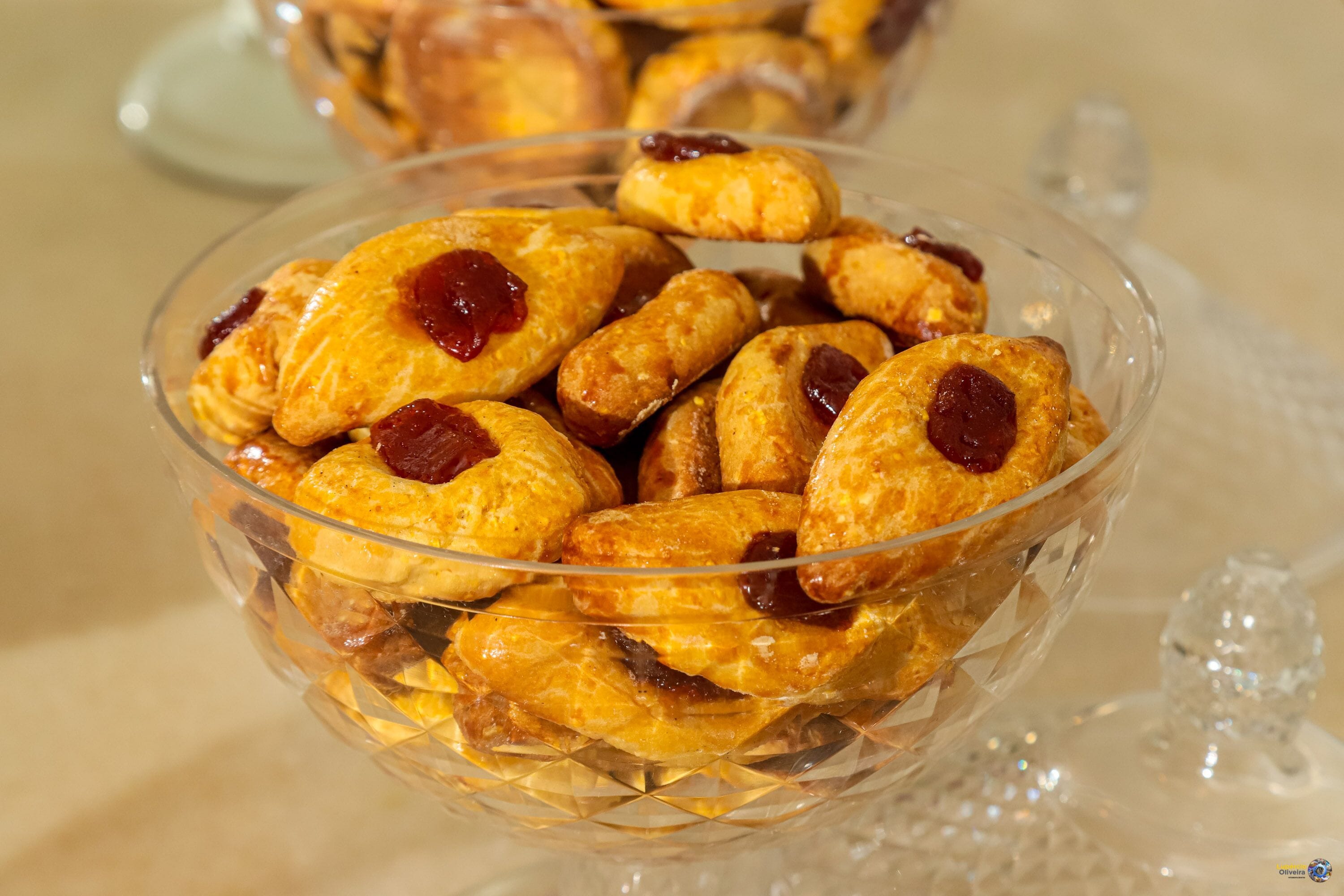 A glass bowl filled with pastries topped with red jam.