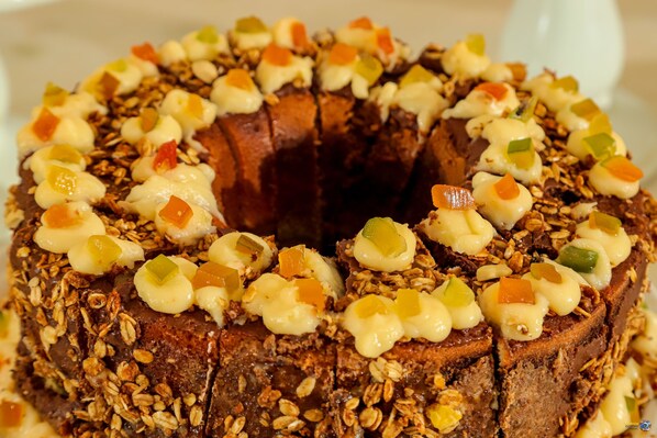 Un pastel bundt de chocolate con granola y verduras picadas por encima.