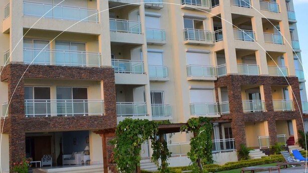A hotel with a swimming pool, outdoor seating, and a stone facade. - Wonderful penthouse with pool and sea view (La Romana)