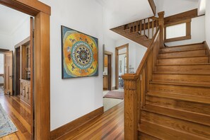 Stunning hallway with a beautiful abstract painting and elegant staircase.