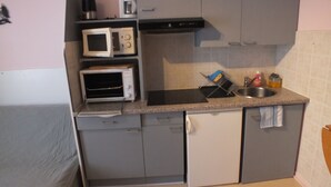 A compact kitchen with a microwave, toaster, and sink. - F2 apartment near the spa. (La Bourboule)