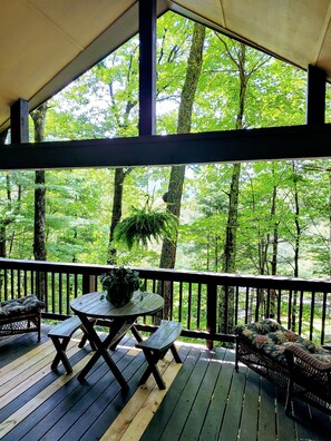 A covered deck with a table and benches, surrounded by trees. - Sky Valley Resort Family Retreat (Sky valley)