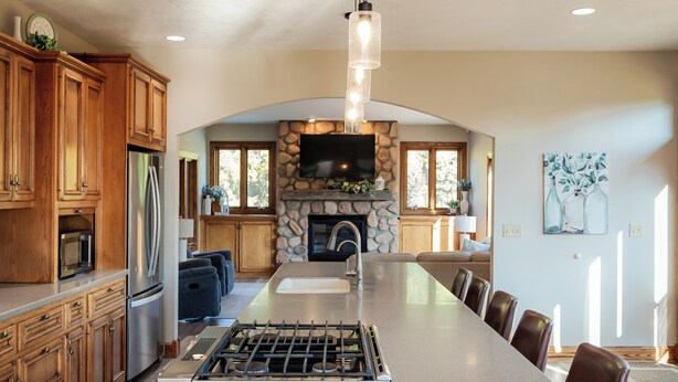 A spacious kitchen with a large island, wooden cabinets, a built-in stove, and a stone fireplace. - Indoor Gymnasium, Seasonal Pool, 7 Bedroom, Sleeps 28 (Fort recovery)
