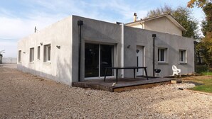 A modern building with a flat roof, large sliding glass doors, and a small deck area. - GITES EN COLLOCATION 33500 NEAC (Néac)