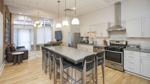 A modern kitchen with a central island, stainless steel appliances, and pendant lighting. - The Record Room -steps to Broadway & Printer’s Alley (Nashville)