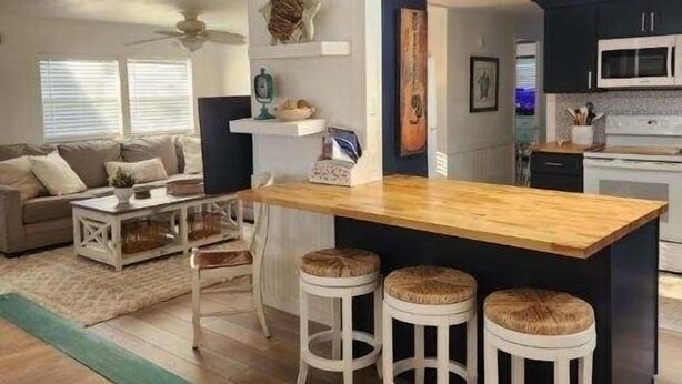 Une cuisine moderne dotée d’un îlot central, de tabourets de bar et d’un coin repas comprenant un canapé et une table basse.