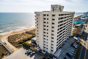 Un hotel de varios pisos con estacionamiento y vista al mar.