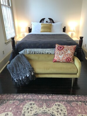Relax in this inviting bedroom with a large bed, sofa, and decorative throw blanket.