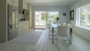 Una cocina moderna con comedor, ventanas amplias y vistas al exterior.