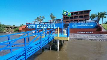 Un puente azul que lleva a un edificio con la señalización 'HOTEL MARAZUL'.