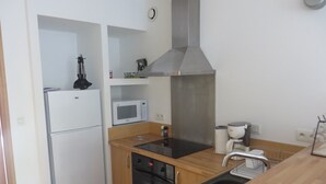 Una cocina compacta equipada con refrigerador, microondas, estufa, horno y lavaplatos.