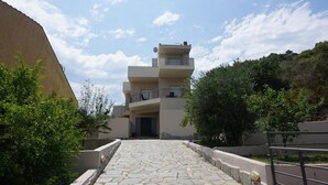 A multi-story building with a stone-paved pathway leading to the entrance. - Villa Seaview          . (Palio, Kavala)