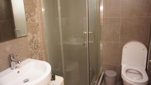 A bathroom with a glass shower enclosure, a sink, and a toilet. - Villa Seaview          . (Palio, Kavala)