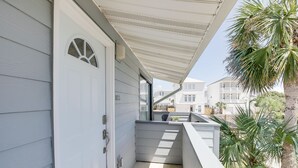 A covered balcony with a white door, a small window, and a view of neighboring buildings. - Cozy Condo, 3 Minute Walking Distance to the Beach (Destin)