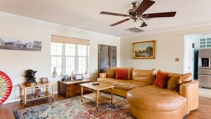 A living room with a leather sofa, wooden coffee table, and a ceiling fan.