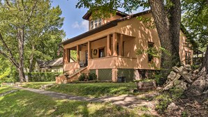 A two-story house with a porch, a front yard, and a large tree. - Country-Chic Cotter Home w/ Outdoor Living Space! (Cotter)