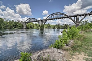 A large suspension bridge over a river with lush greenery and trees on both sides. - Country-Chic Cotter Home w/ Outdoor Living Space! (Cotter)