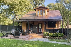 A two-story house with a porch, outdoor seating, and a barbecue area. - Country-Chic Cotter Home w/ Outdoor Living Space! (Cotter)