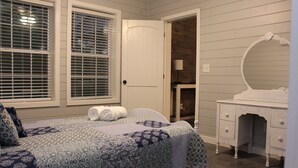 A bedroom with a bed, a dresser, a mirror, and a door leading to another room. - Secluded Retreat With hot tub ideal to fish and relax on private pond (Orangeburg)