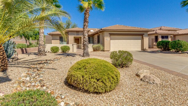 A residential house with a garage, palm trees, and a well-maintained garden with rocks and shrubs. - 3BR w walking trail, 45+ community, patio (Surprise)