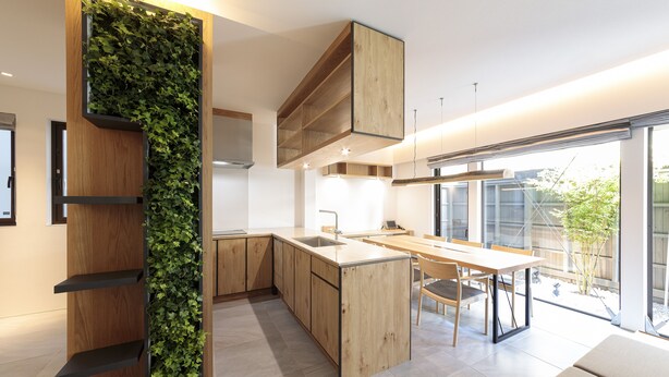 A modern kitchen with wooden cabinetry, a built-in herb garden, a central island, and large windows offering a view of the outdoors. - Ishitei furano (Furano)