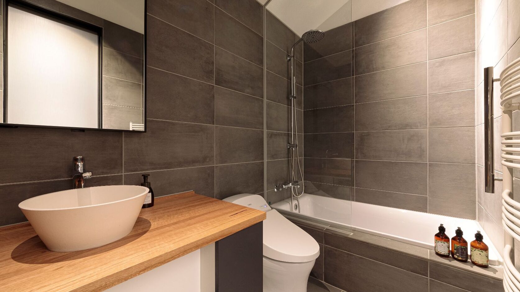 A modern bathroom with a freestanding bathtub, a sink with a large basin, a toilet, and a shower area.