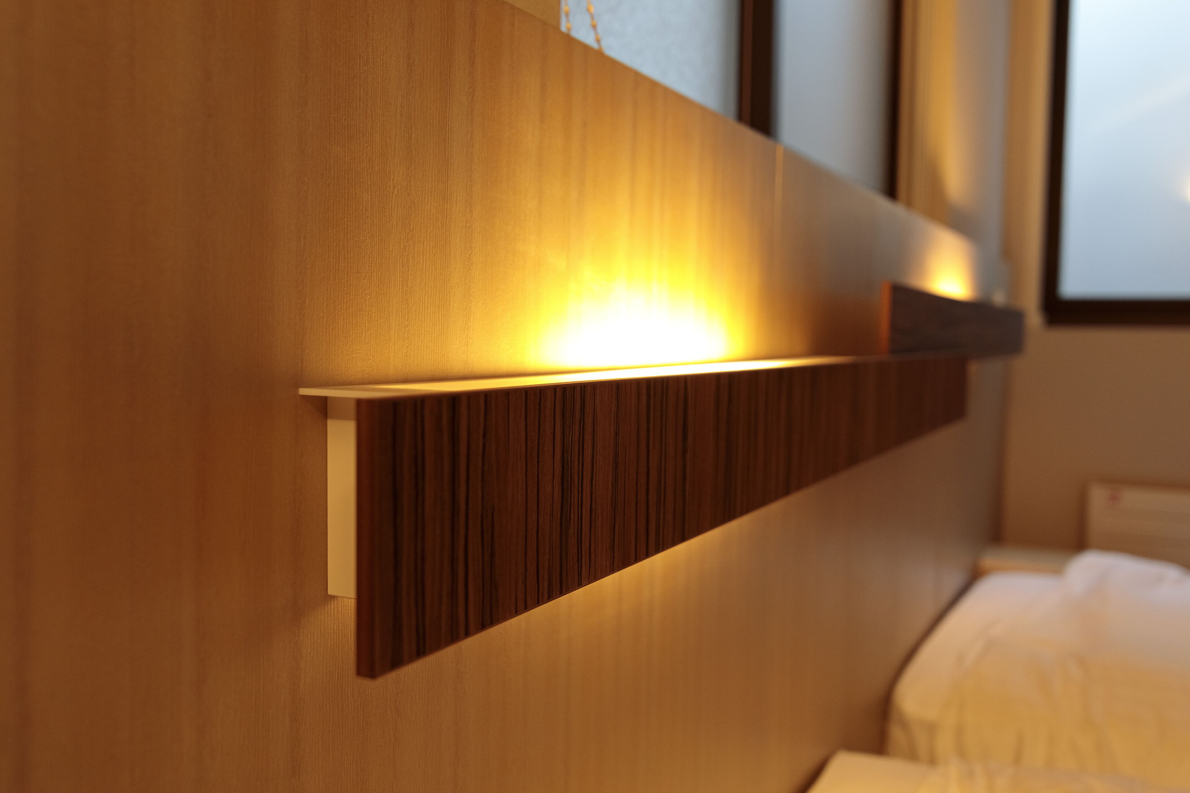 A modern room with a wooden headboard, a bedside table, and a bed.