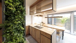 A modern kitchen with wooden cabinets, a stainless steel sink, and a built-in herb garden. - Ishitei furano (Furano)