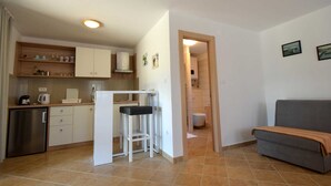 A compact living space with a kitchenette, a dining area, and a seating area. - Studio apartment Depope 1 (Skrbčići)