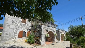 A stone building with arched doorways and a covered walkway. - Studio apartment Depope 1 (Skrbčići)