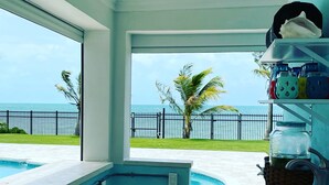 Una cucina con vista sull'oceano, una piscina e una recinzione.
