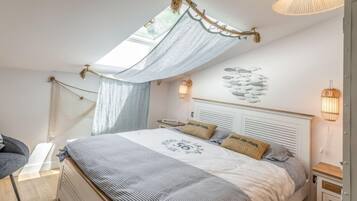 Een slaapkamer met een bed, een hemelbed, een wandlamp en een nachtkastje.