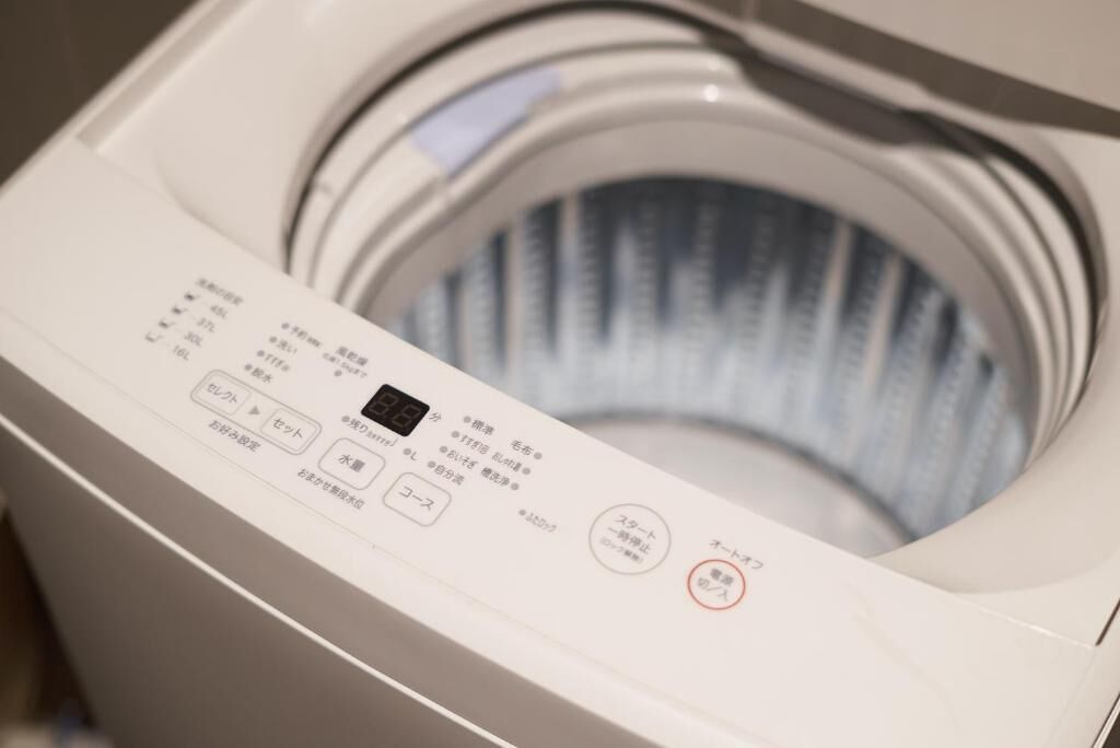 A front view of a washing machine with a control panel displaying various settings and options.