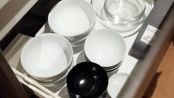 A drawer containing various white and black bowls and plates.