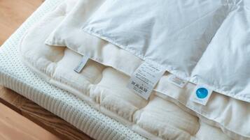 Un matelas recouvert d’une housse blanche et portant plusieurs étiquettes, dont une étiquette bleue.
