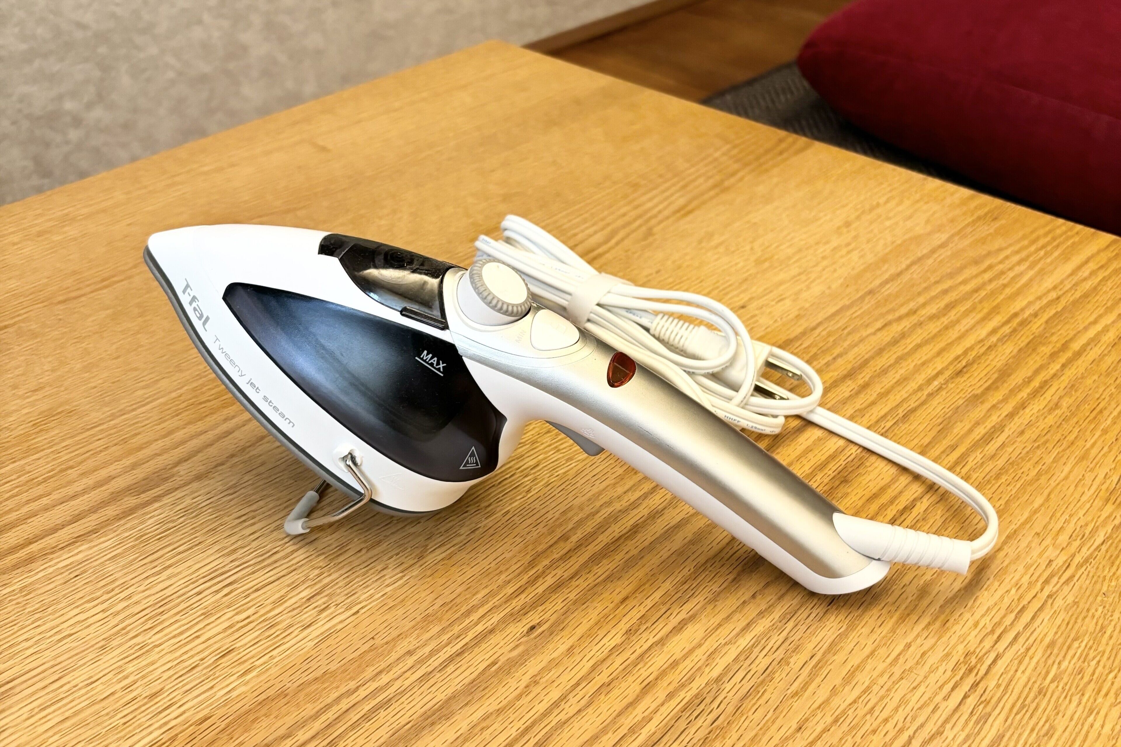 A white and silver electronic device with a screen and buttons, placed on a wooden table.