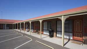 A motel with a covered parking area, multiple rooms with large windows, and a brick facade. - Horsham Country City Motor Inn (Horsham)